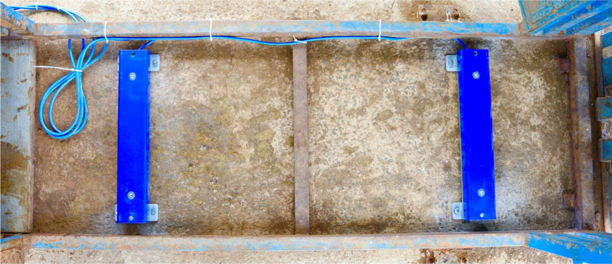 Two load bars fixed to a concrete pad inside a chute with dynabolts